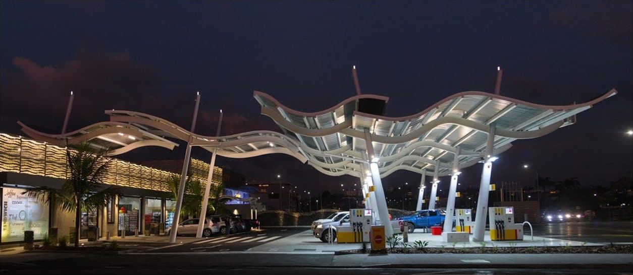Canopée métallique en forme de vagues éclairée au-dessus de la station Victoire, ciel de crépuscule